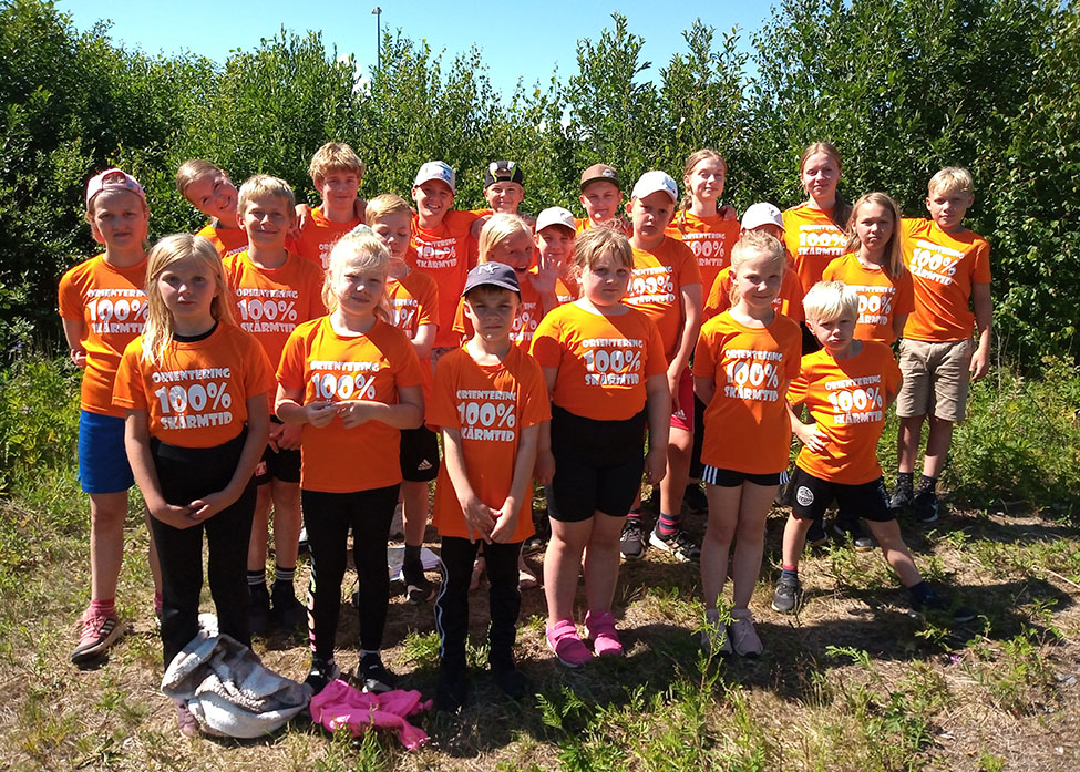 En grupp barn och unga i orange klubbtröjor.