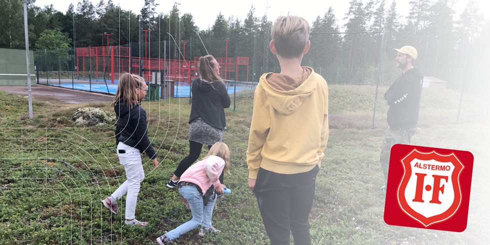 Familj på två vuxna och tre barn roar sig utomhus i Alstermo. 