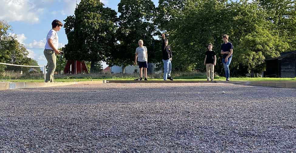 Barn och ungdomar som spelar boule utomhus