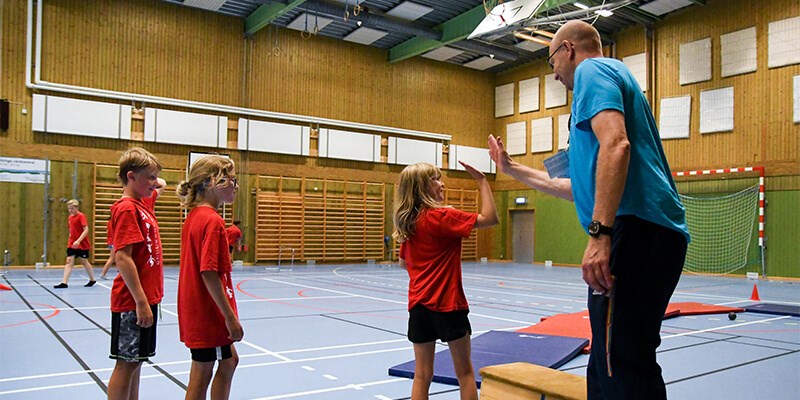 En tränare gör high five med barnen på träningspasset. 